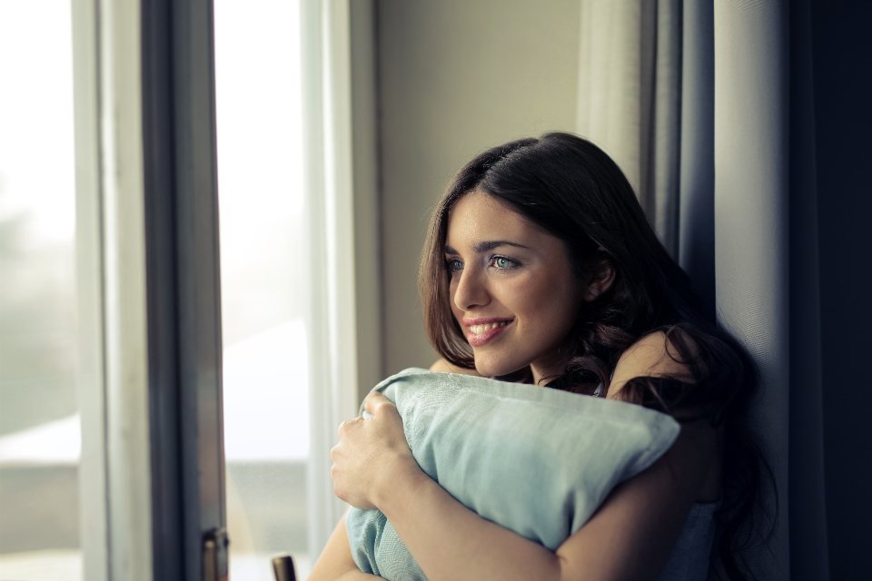 Mujer sonriendo junto a una ventana