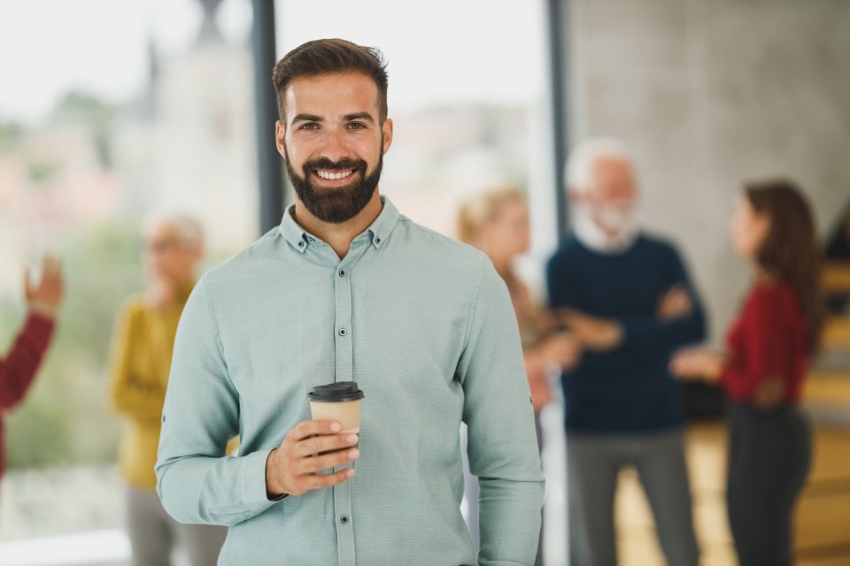 Hombre sonriendo con un café